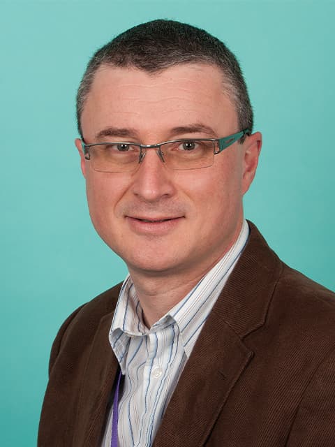 headshot of Mark with a teal background